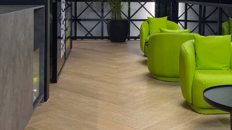 Sports club waiting area with green chairs and a timber floor