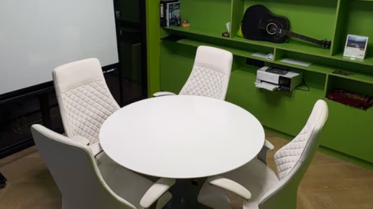 Sports club break area with a round white table and upholstered chairs