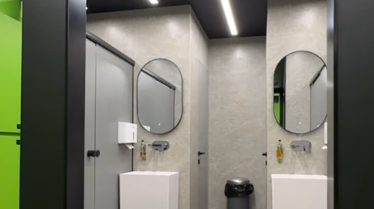 Sports club washroom with twin mirrors and wall-mounted basins