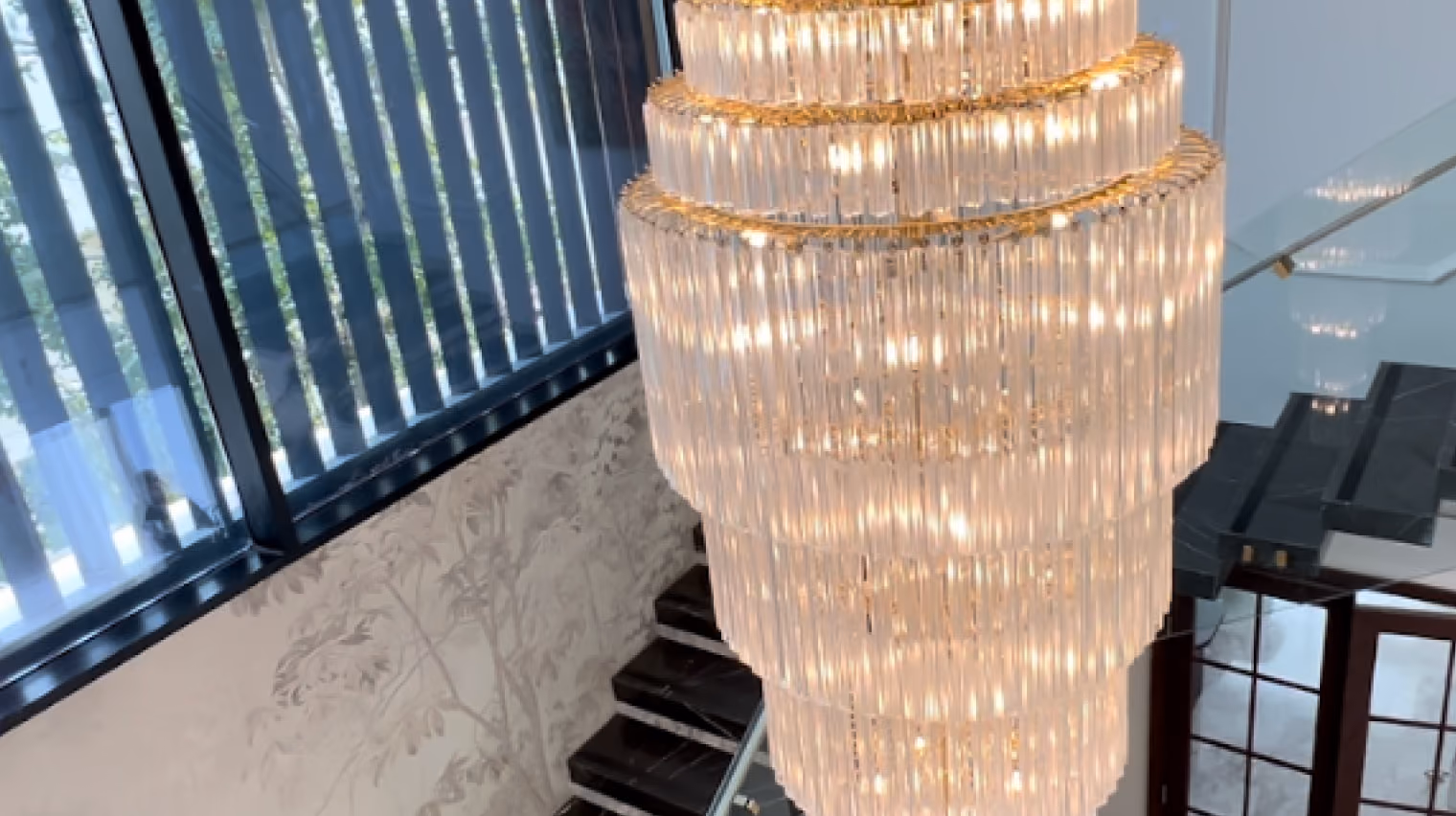 Brow & Beauty chandelier beside a glazed stairwell