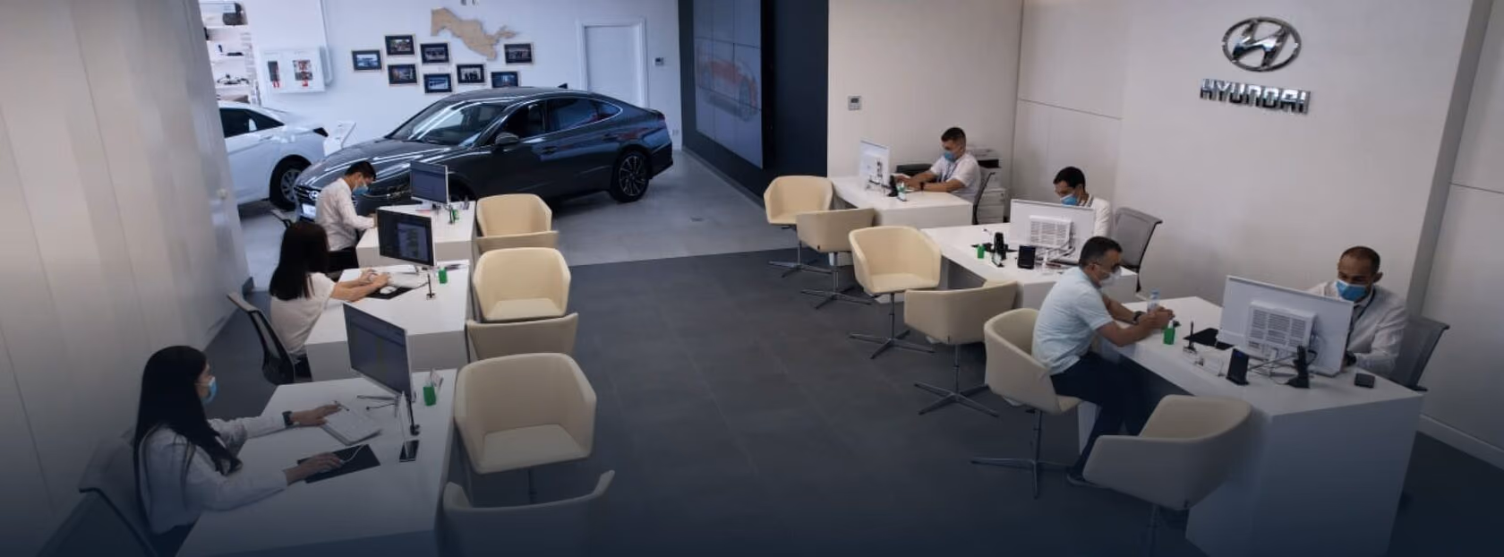 Mijozlar stollari, oʻrindiqlar va avtomobillar ekspozitsiyasiga ega Oʻzbekistondagi Hyundai avtosaloni