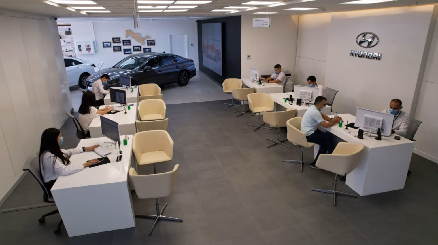 Hyundai showroom customer service desks and seating beside a vehicle display