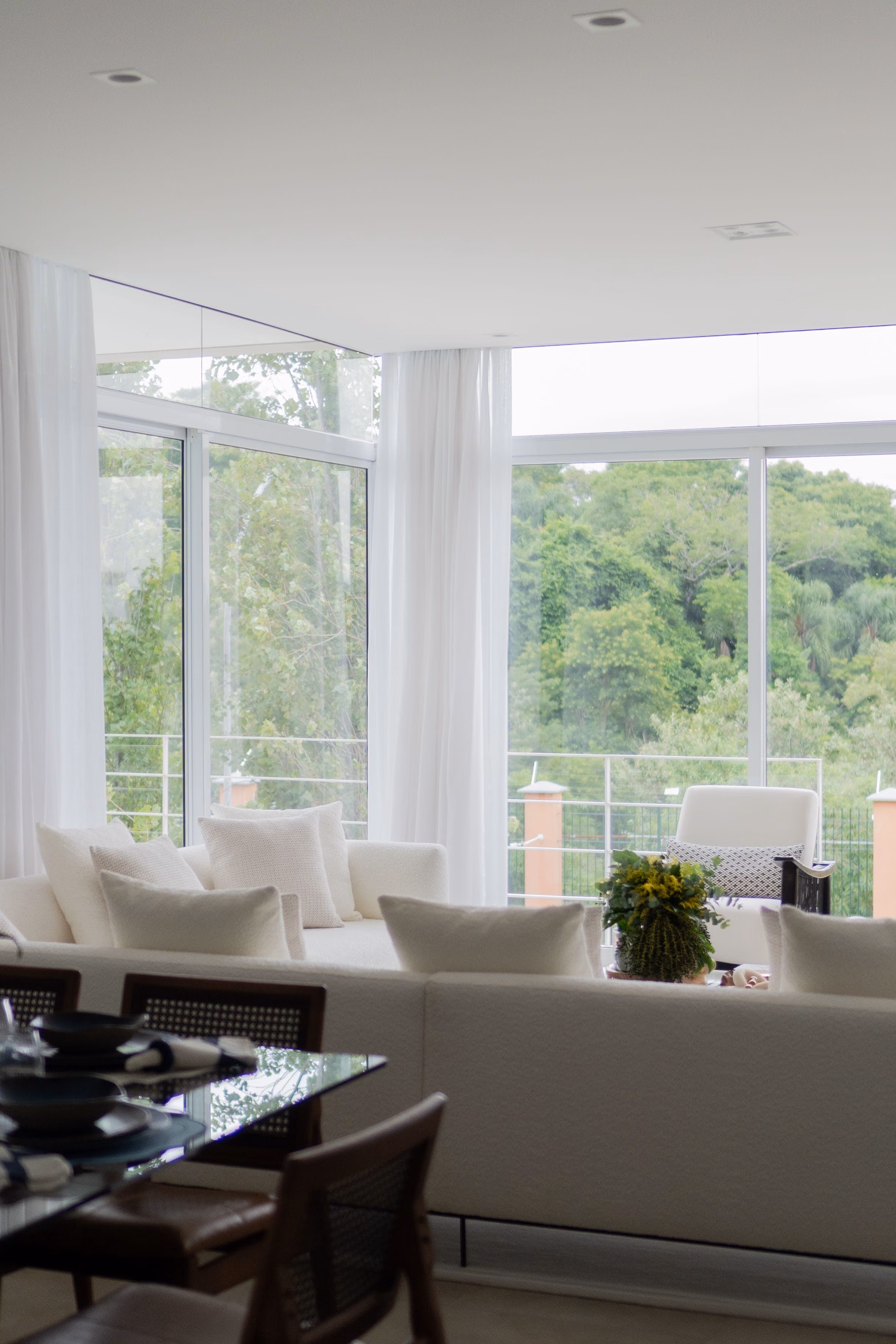 Bright living area with floor-to-ceiling windows, sheer curtains and recessed ceiling lights
