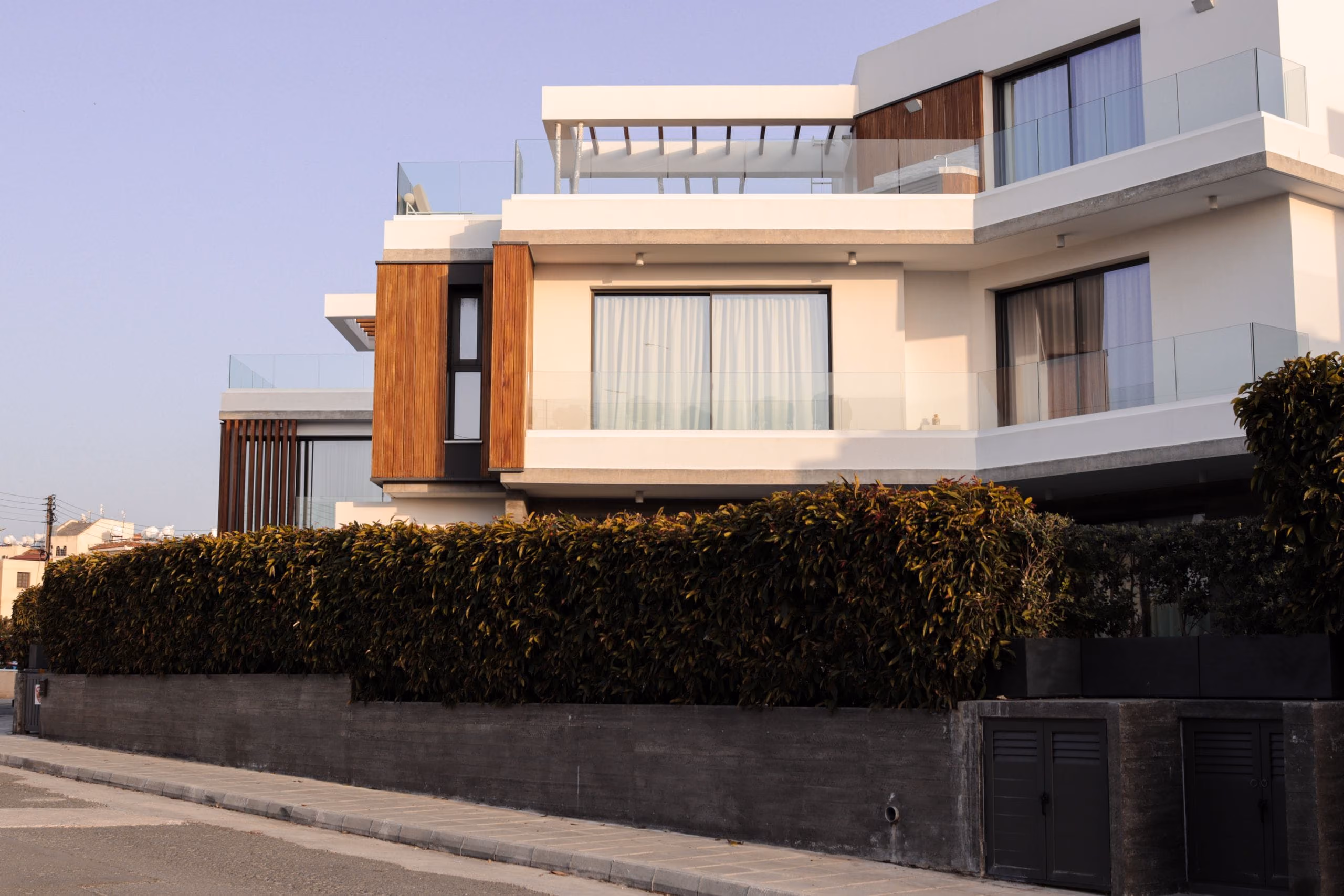 Contemporary white villa with flat roof terraces, glass balustrades and timber cladding