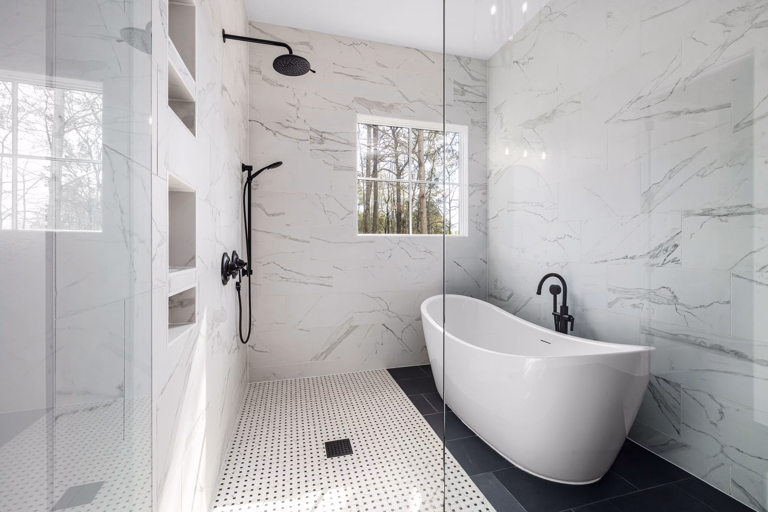 Bathroom with large-format white marble-look tiles, freestanding bathtub and open rain shower