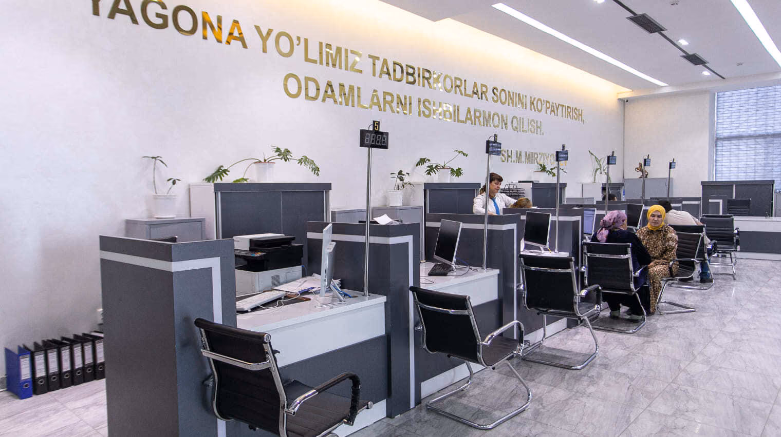 مكاتب خدمة عملاء Xalq Bank بحواسيب ولافتة جدارية