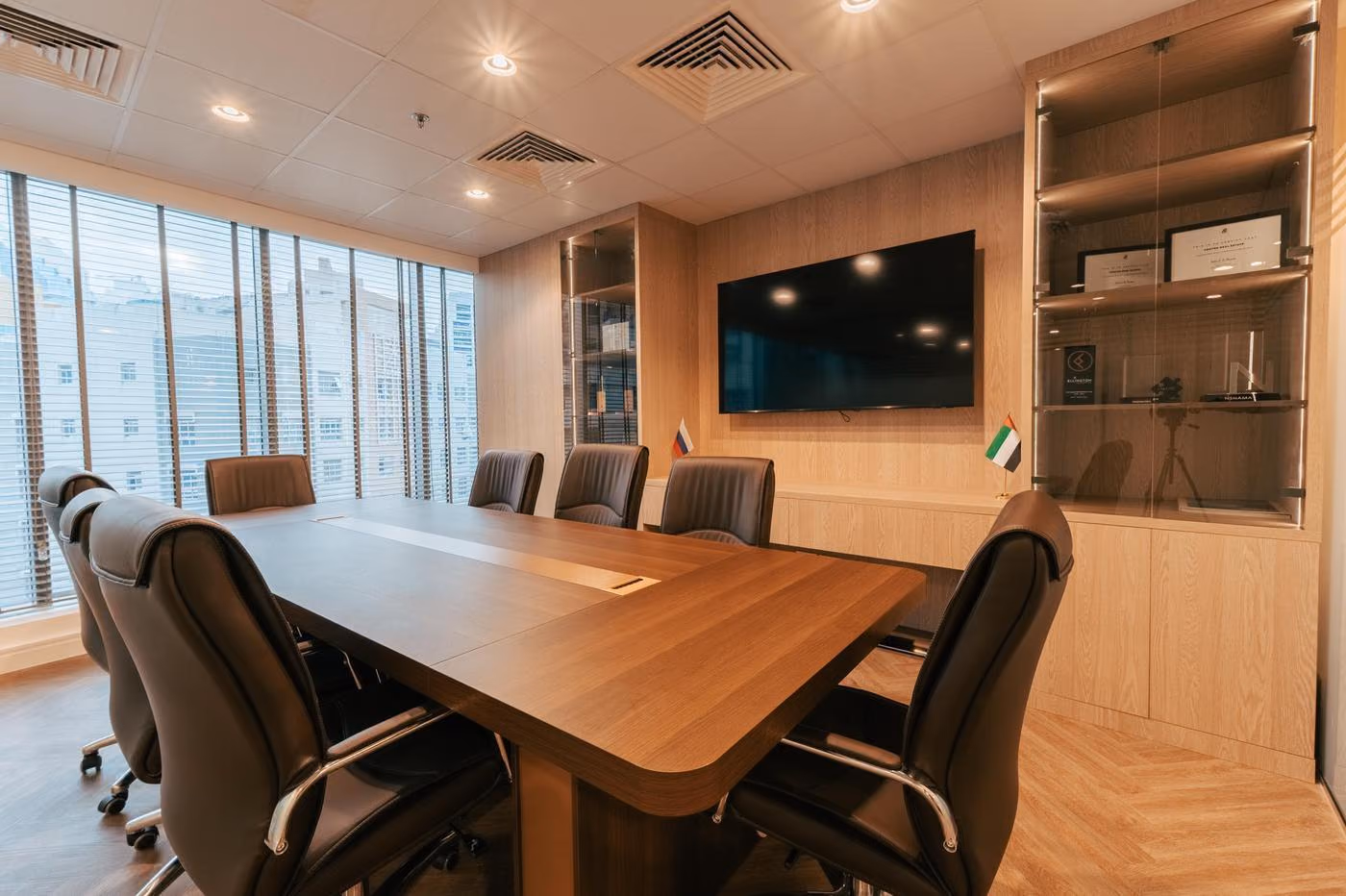 Vostok Real Estate meeting room with a timber table, TV screen and display cabinets