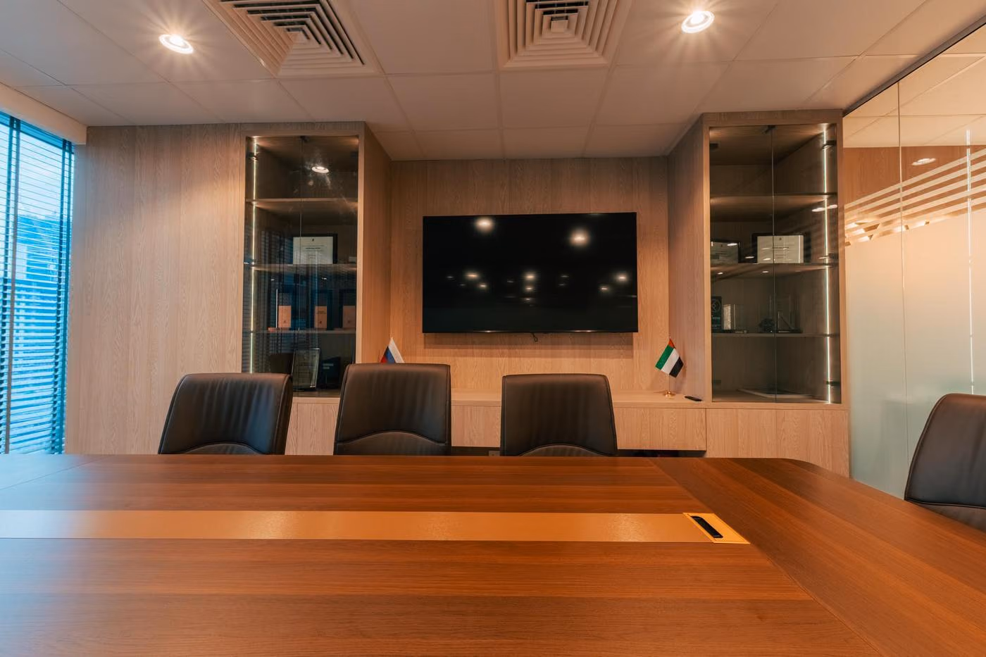 Vostok Real Estate meeting room with glazed partitions and a wood-panelled TV wall